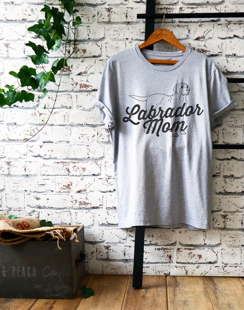 May include: Gray t-shirt with a black outline of a Labrador Retriever and the text "Labrador Mom" in a black script font.