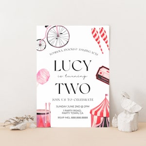 May include: A pink and red circus-themed birthday party invitation for a girl turning two. The invitation features a bicycle, a cotton candy, a red and white striped tent, and a red and white striped juggling club. The text on the invitation reads "TOMBOLA, SNACKS & AMAZING ACTS LUCY is turning TWO JOIN US TO CELEBRATE SUNDAY JUNE 2ND @ 2PM 1 PARTY ROAD, PARTY TOWN, CA RSVP MEL 888.888.8888"