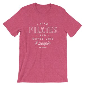 Pode incluir: Uma camiseta rosa heather com texto branco que diz "Eu gosto de Pilates - e - talvez como 3 pessoas" e "Stag & Peach Co."