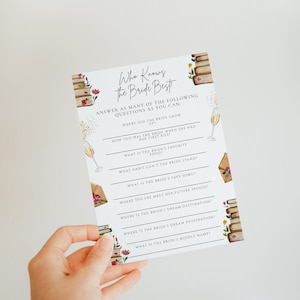 May include: A white card with a pink and green floral design and a stack of books. The card has the text "Who Knows the Bride Best" and a list of questions about the bride.