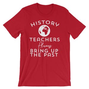 Puede incluir: Camiseta roja con texto blanco que dice "HISTORY TEACHERS Always BRING UP THE PAST". Un contorno blanco de la Tierra est&aacute; por encima de la palabra "TEACHERS".