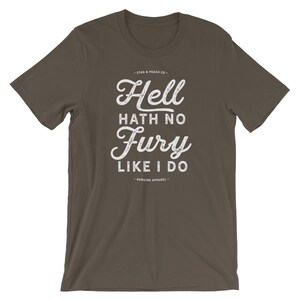Puede incluir: Una camiseta marr&oacute;n oscuro con un estampado gr&aacute;fico blanco que dice "Hell hath no fury like I do". El gr&aacute;fico est&aacute; en una fuente de estilo vintage con un efecto desgastado. Los textos "Stag & Peach Co." y "Genuine Apparel" tambi&eacute;n est&aacute;n impresos en blanco en la camiseta.