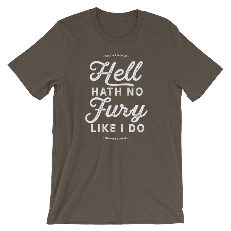Puede incluir: Una camiseta marr&oacute;n oscuro con un estampado gr&aacute;fico blanco que dice "Hell hath no fury like I do". El gr&aacute;fico est&aacute; en una fuente de estilo vintage con un efecto desgastado. Los textos "Stag & Peach Co." y "Genuine Apparel" tambi&eacute;n est&aacute;n impresos en blanco en la camiseta.