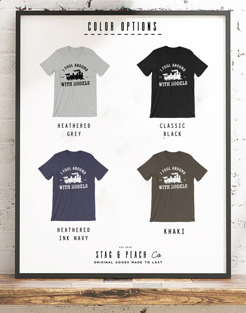 May include: A graphic t-shirt design featuring a train with the text "I fool around with models". The shirt is available in five colors: heather grey, classic black, heather ink navy, khaki, and white.