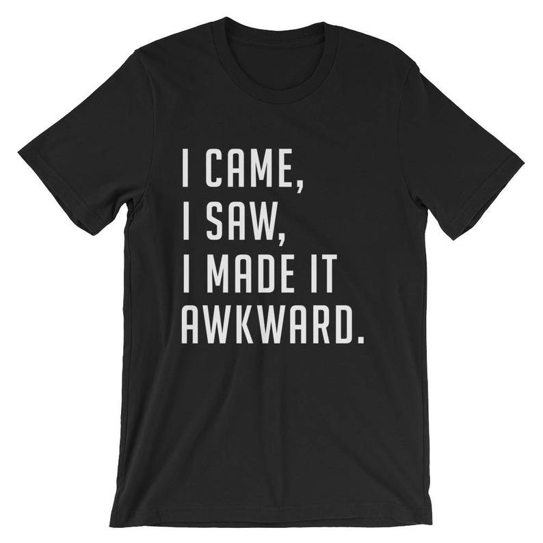 Puede incluir: Camiseta negra con el texto blanco "I CAME, I SAW, I MADE IT AWKWARD." La camiseta de manga corta tiene cuello redondo. El texto est&aacute; centrado en la parte delantera de la prenda.