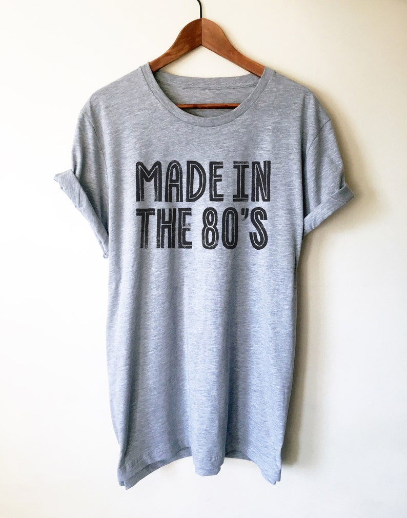 May include: A heather grey t-shirt with black text that reads "Made in the 80's".