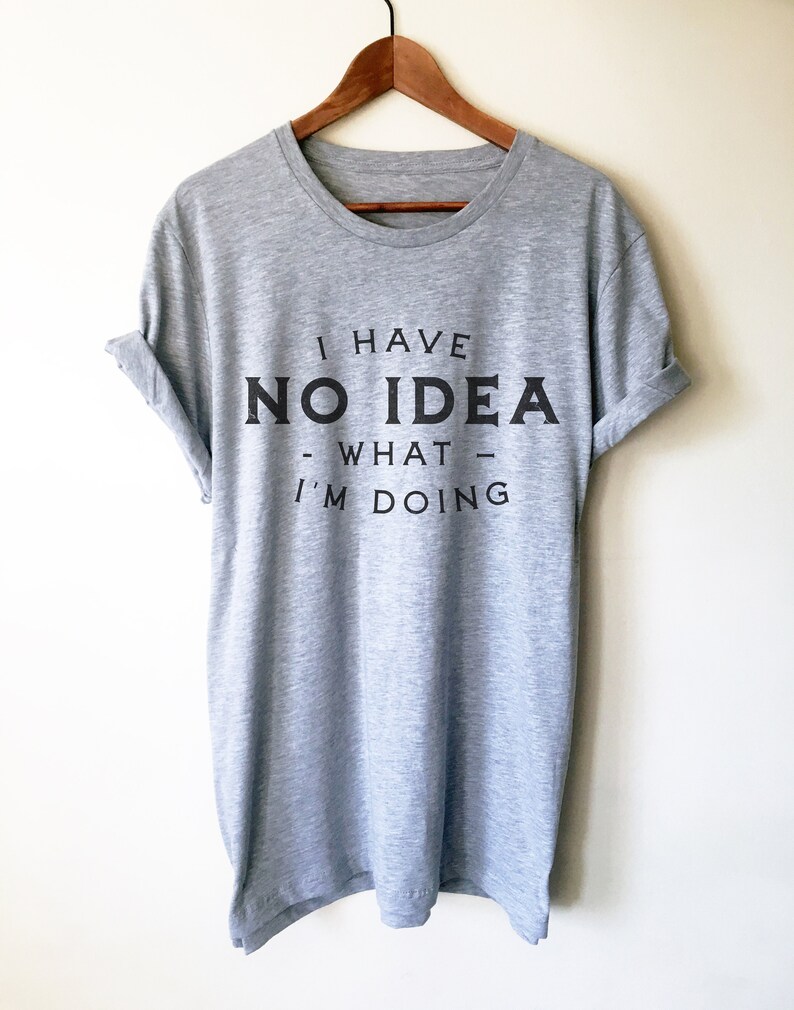 May include: A heather grey t-shirt with the text "I have no idea what I'm doing" printed in black.