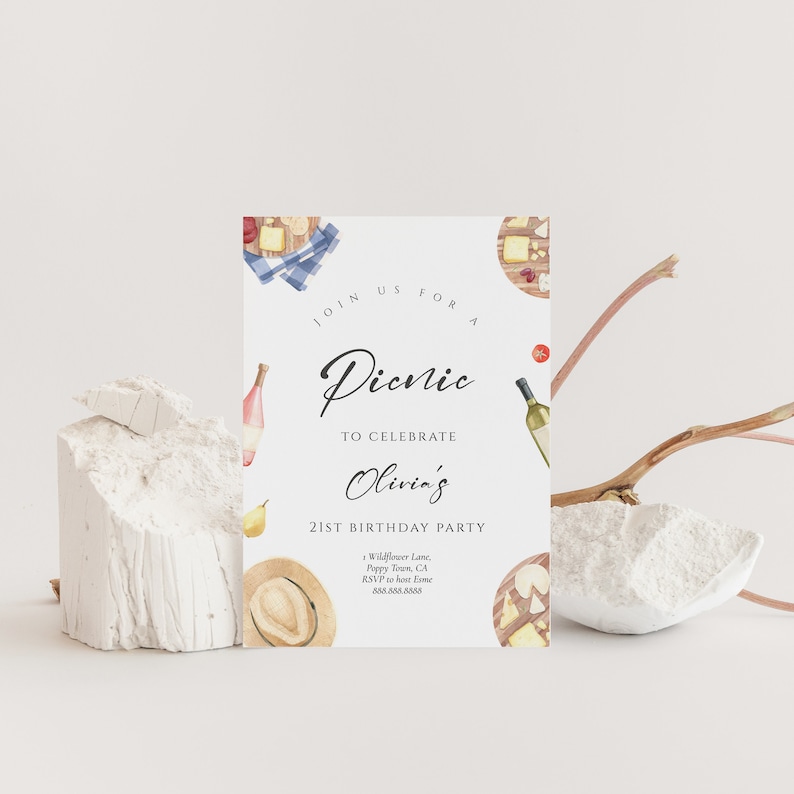 May include: A white invitation card with a watercolor illustration of a picnic basket, cheese, wine, and a hat. The text on the card reads "Join us for a Picnic to celebrate Olivia's 21st Birthday Party".