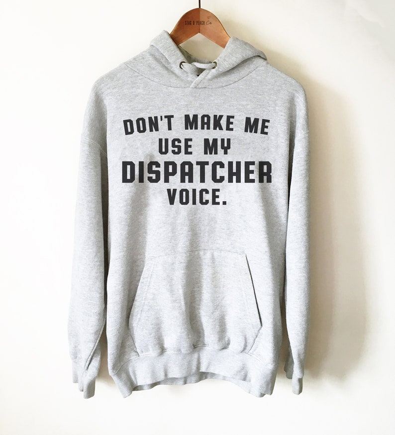 May include: A gray hooded sweatshirt with the text "DON'T MAKE ME USE MY DISPATCHER VOICE." printed in black.