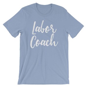 May include: Light blue t-shirt with the text "Labor Coach" in white lettering.