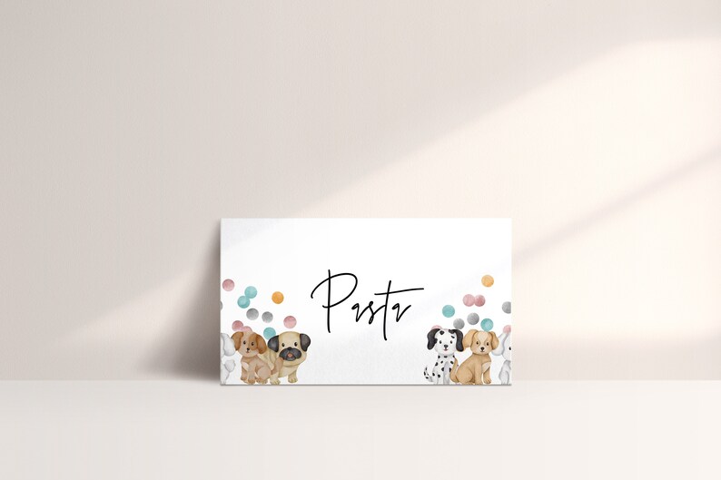 May include: A white card with the name "Pustv" written in black cursive. The card is decorated with colorful confetti and three cartoon dogs. The dogs are a pug, a dalmatian, and a brown and white dog.