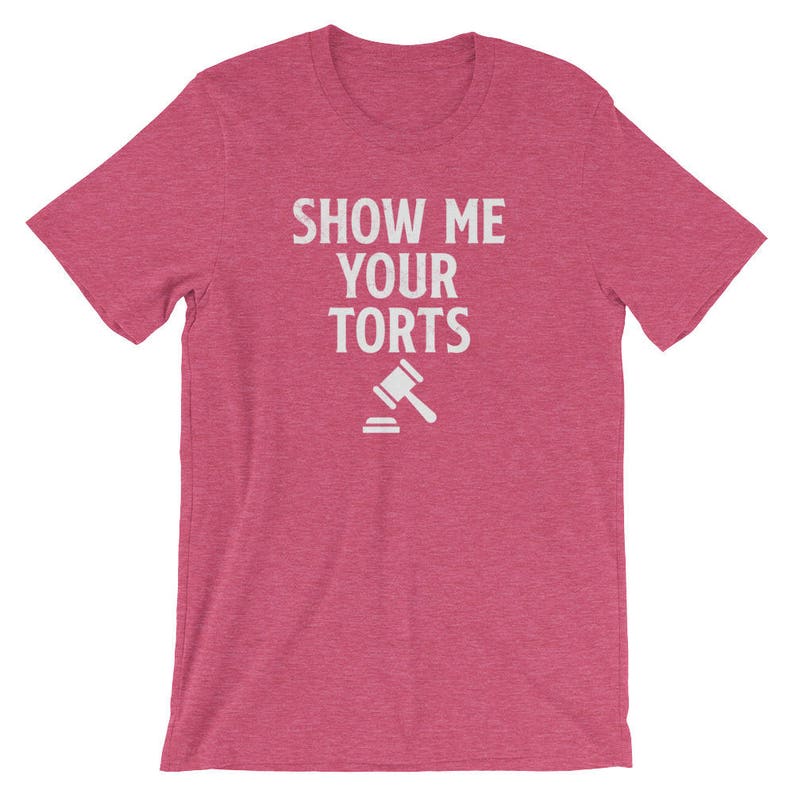 May include: A pink t-shirt with the text "SHOW ME YOUR TORTS" in white lettering and a white gavel icon.