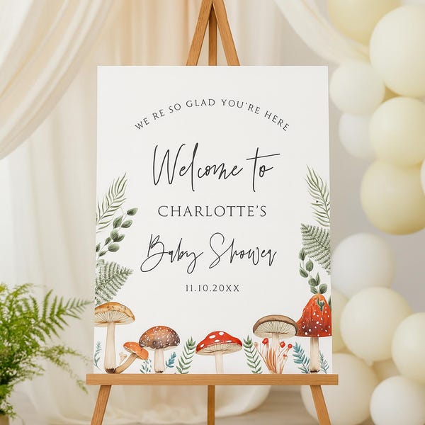 May include: A baby shower welcome sign on a wooden easel. The sign reads "Welcome to Charlotte's Baby Shower" with a mushroom and fern design. The date 11.10.20XX is also displayed.