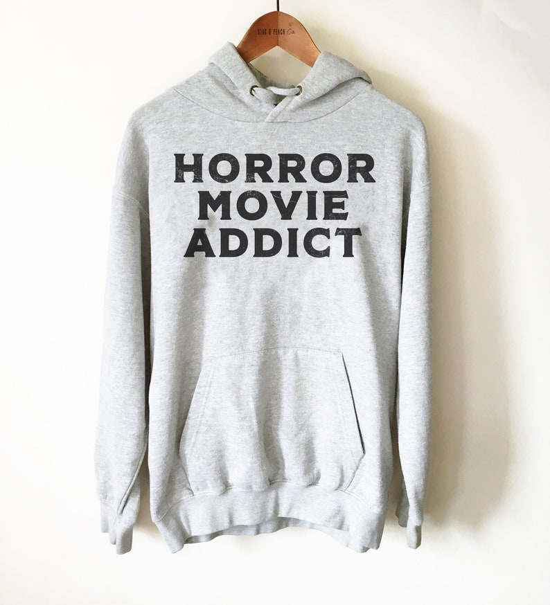 May include: A gray hooded sweatshirt with the text "HORROR MOVIE ADDICT" printed in black on the front.