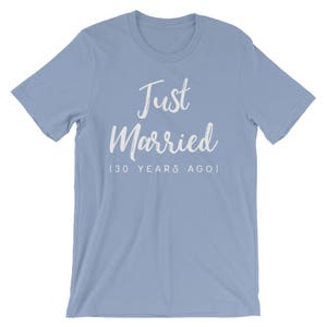 May include: Light blue t-shirt with white text that reads "Just Married (30 Years Ago)"