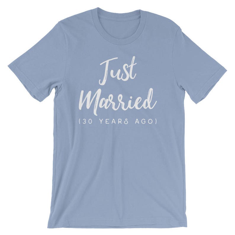 May include: Light blue t-shirt with white text that reads "Just Married (30 Years Ago)"