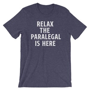 May include: A dark blue t-shirt with white text that reads "Relax the Paralegal is Here".