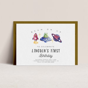 Peut inclure: Une carte d'invitation blanche avec une enveloppe dorée. La carte présente une illustration aquarelle d'une fusée, d'un OVNI et d'une planète. Le texte sur la carte indique "Beam On Up" et "Pour célébrer le premier anniversaire de Lincoln". L'invitation comprend la date, l'heure, le lieu et les informations RSVP.