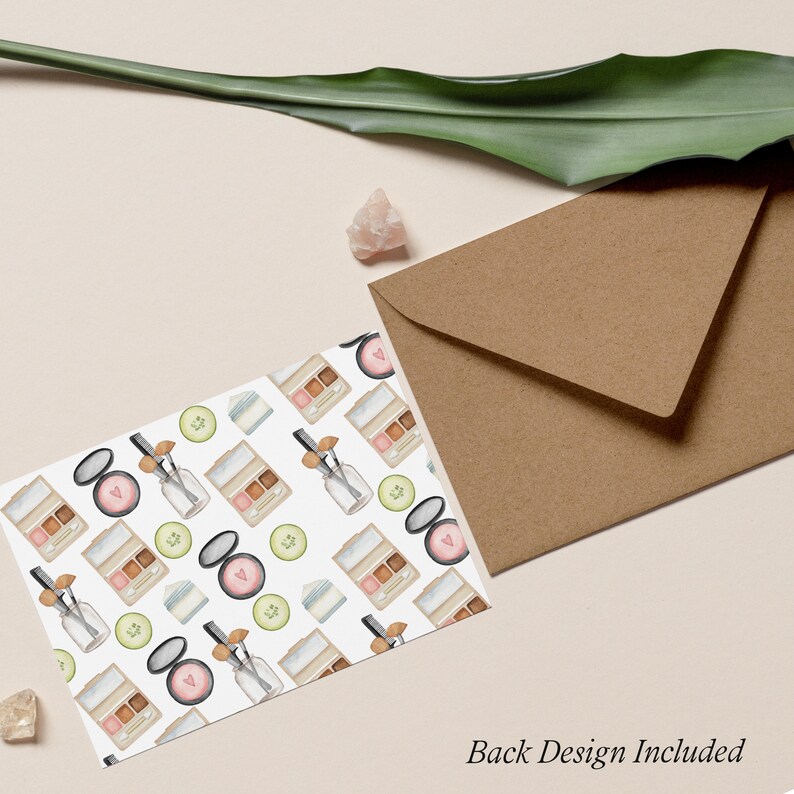 May include: A white card with a repeating pattern of watercolor illustrations of makeup products, including eyeshadow palettes, blush compacts, and bottles of face serum. The card has a brown envelope behind it.