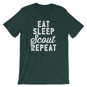 May include: A dark green t-shirt with white text that reads "Eat Sleep Scout Repeat".