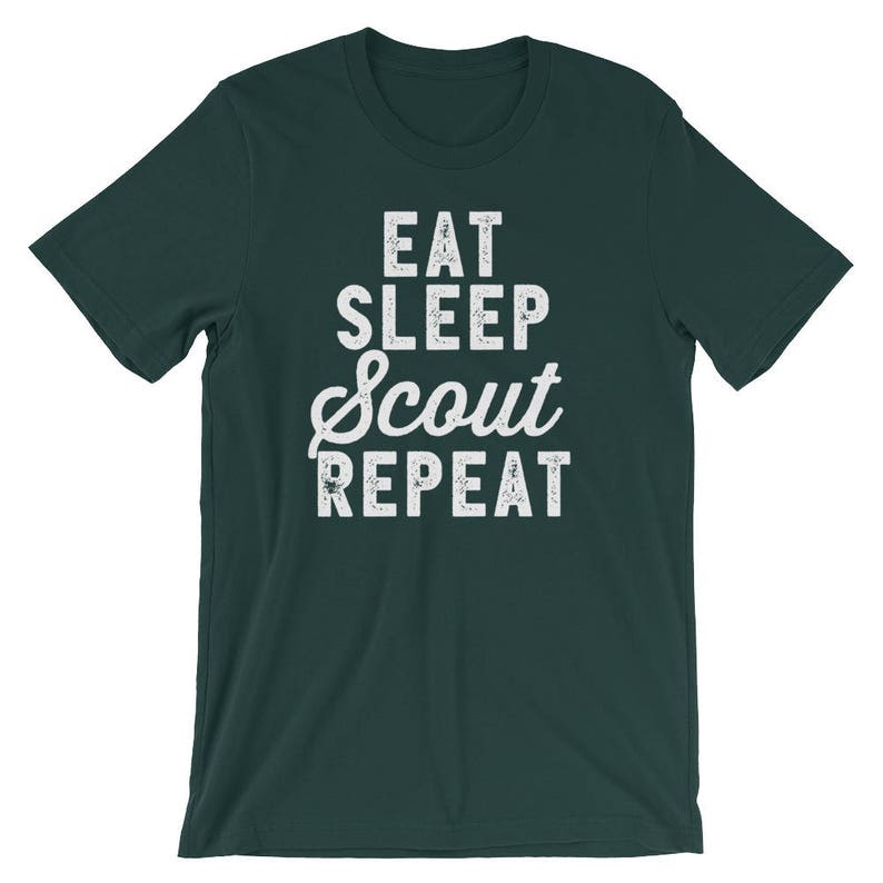 May include: A dark green t-shirt with white text that reads "Eat Sleep Scout Repeat".