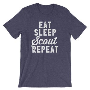 May include: A navy blue t-shirt with a white distressed graphic that reads "Eat Sleep Scout Repeat".