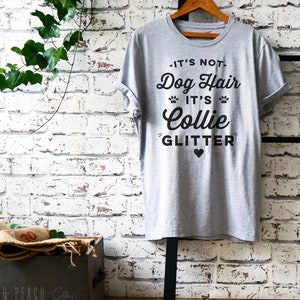 Puede incluir: Camiseta gris con un gr&aacute;fico negro que dice "No es pelo de perro, es brillo de Collie" con un peque&ntilde;o coraz&oacute;n negro.