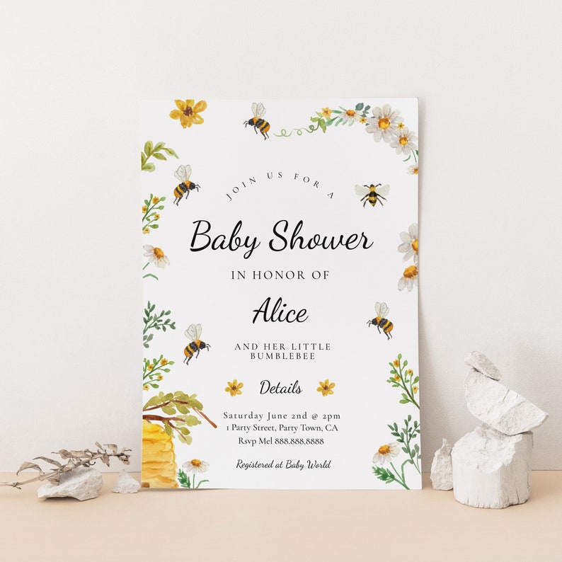 May include: A baby shower invitation with a bee and flower theme. The invitation is white with yellow and green floral accents. The text reads "Join us for a Baby Shower in honor of Alice and her little bumblebee. Details: Saturday June 2nd at 2pm 1 Party Street, Party Town, CA Rsvp Mel 888.888.8888 Registered at Baby World"