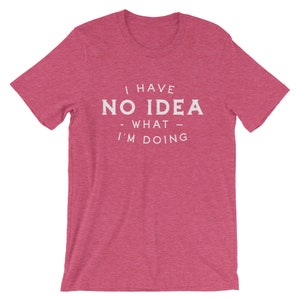 May include: A pink heather t-shirt with the text "I have no idea - what - I'm doing" printed in white.
