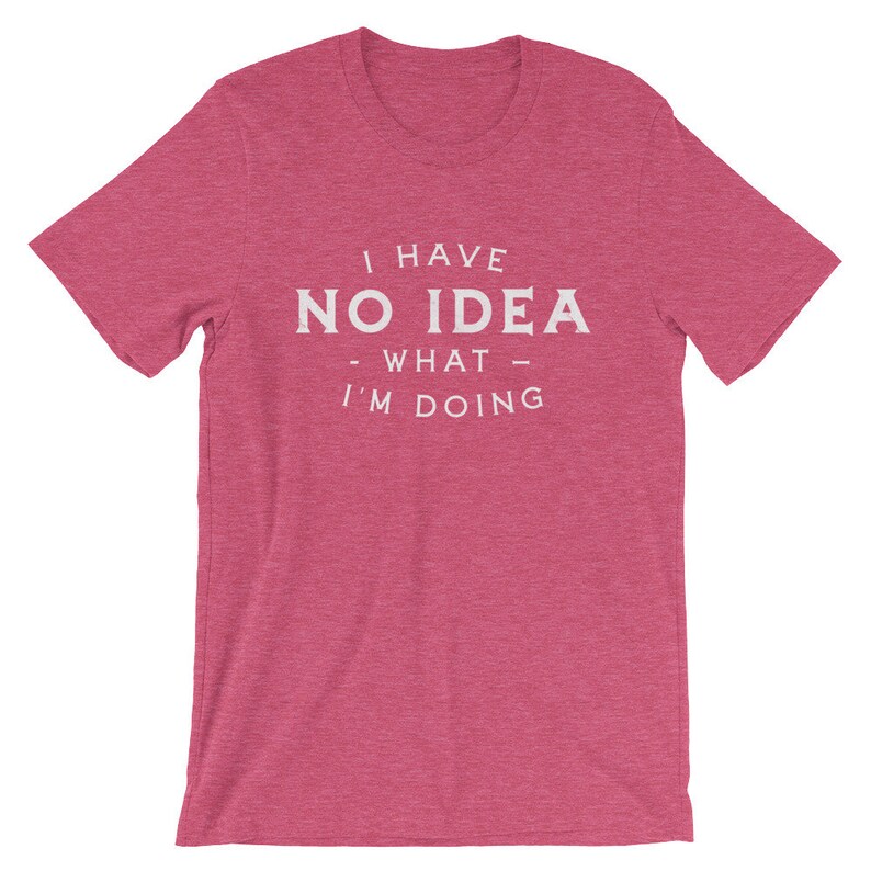 May include: A pink heather t-shirt with the text "I have no idea - what - I'm doing" printed in white.