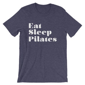 Pode incluir: Uma camiseta azul marinho com texto branco que diz "Eat Sleep Pilates".