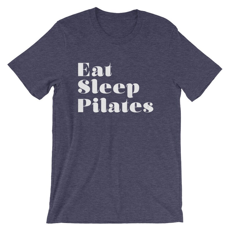 Pode incluir: Uma camiseta azul marinho com texto branco que diz "Eat Sleep Pilates".
