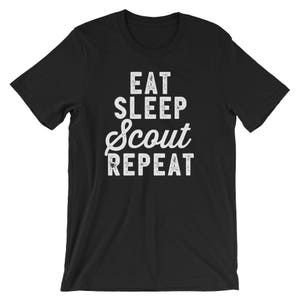 May include: Black t-shirt with white text that reads "Eat Sleep Scout Repeat".