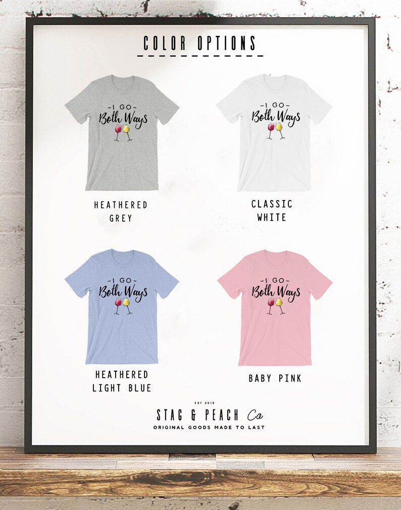 May include: A framed display showcasing four t-shirts in different colors: heathered grey, classic white, heathered light blue, and baby pink. Each shirt features the text "-I GO- Both Ways" with wine glass graphics. The brand name "STAG & PEACH Co" is also visible.