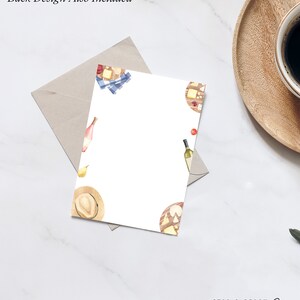May include: A white card with a watercolor design of a cheese board, wine bottles, and a straw hat. The text "Back Design Also Included" is at the top of the card. The text "STAG & PEACH Co" is at the bottom of the card.