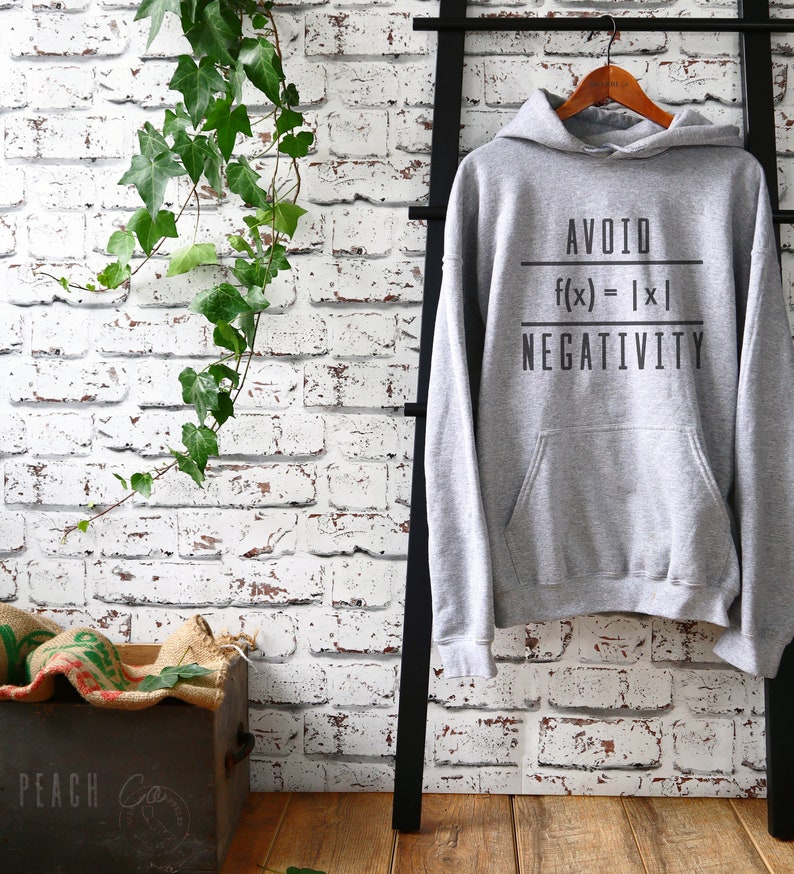 Puede incluir: Sudadera con capucha gris con el texto "AVOID f(x) = |x| NEGATIVITY" impreso en la parte delantera.