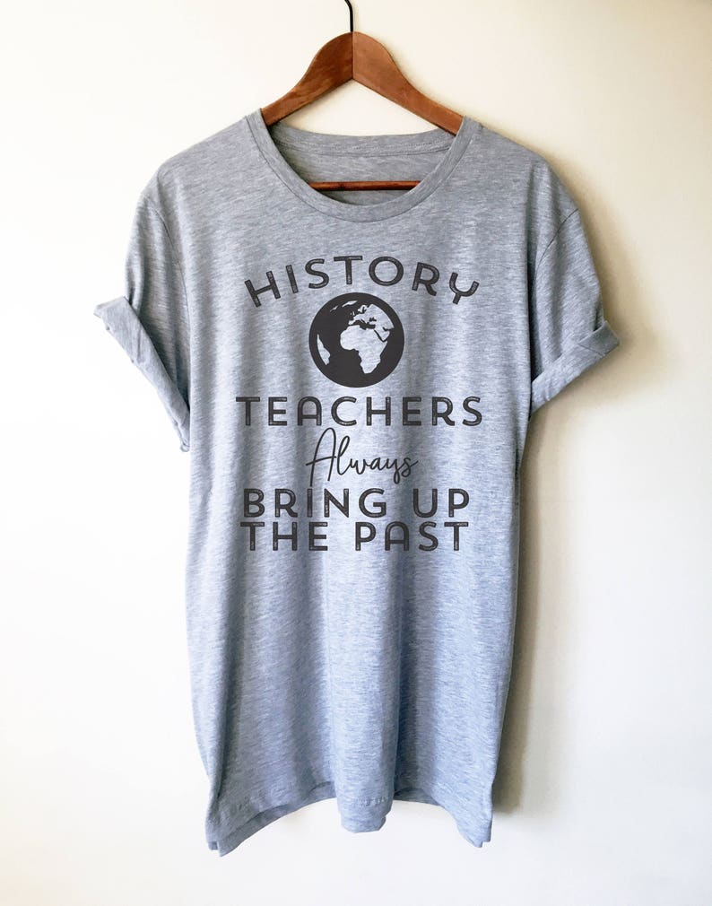 Puede incluir: Camiseta gris con un gr&aacute;fico negro que dice "HISTORY TEACHERS Always BRING UP THE PAST" con un icono de globo terr&aacute;queo.