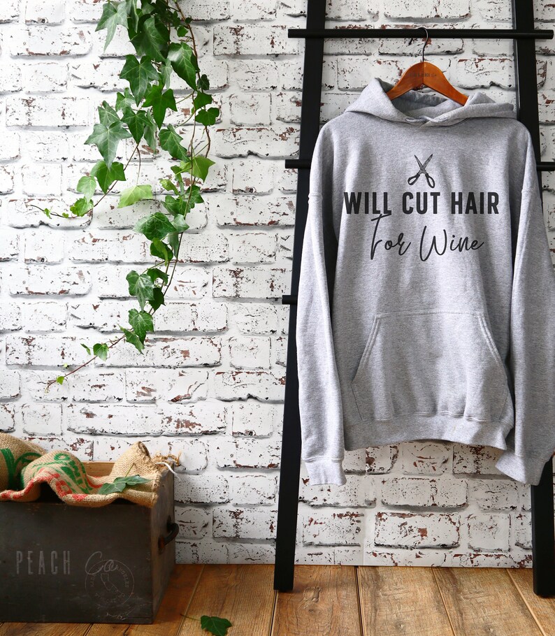 Op de afbeelding: Grijs hoodie met de tekst "WILL CUT HAIR for Wine" en een afbeelding van een schaar.