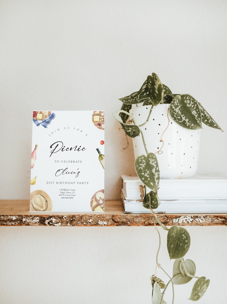 May include: A white card with a watercolor illustration of picnic food and a handwritten invitation to a picnic to celebrate Olivia's 21st birthday party. The invitation includes the date, time, location, and RSVP information.