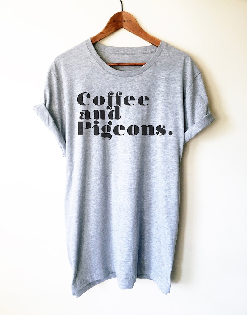Puede incluir: Camiseta gris con texto negro que dice "Coffee and Pigeons."