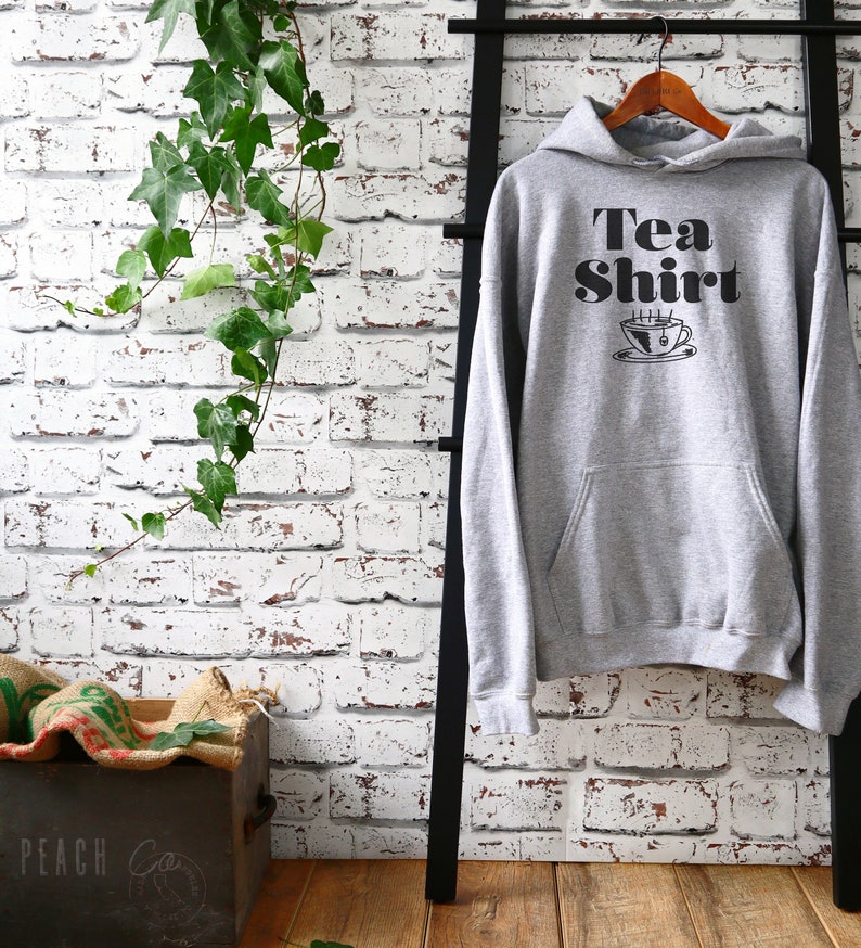 May include: Grey hooded sweatshirt with the text "Tea Shirt" and a black and white illustration of a steaming cup of tea.