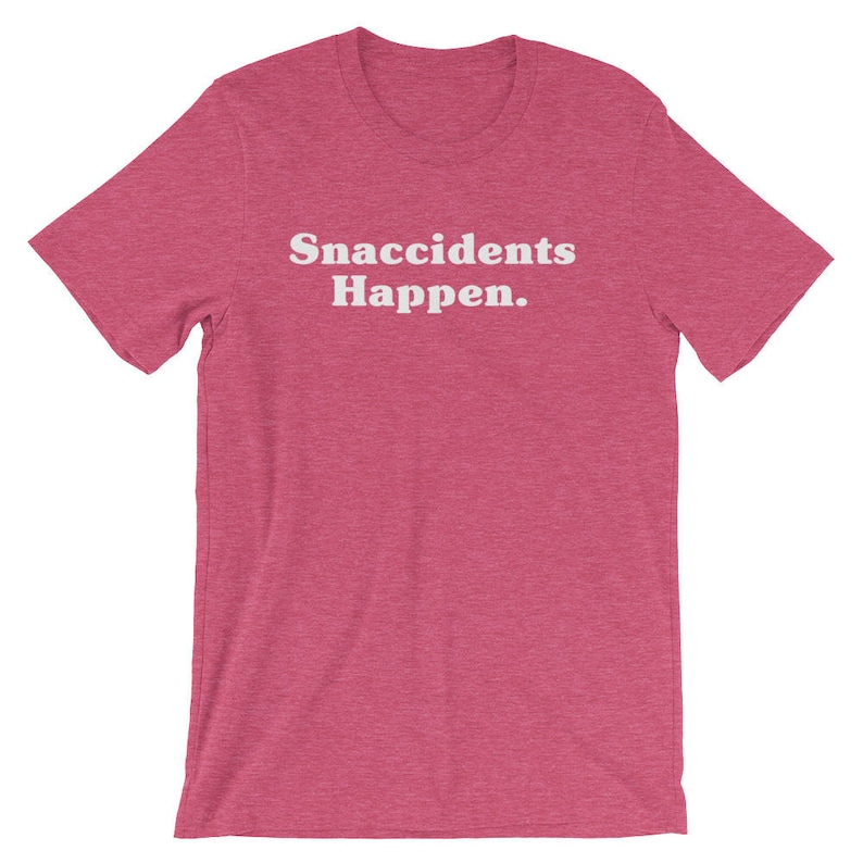May include: A pink t-shirt with the text "Snaccidents Happen." printed in white.
