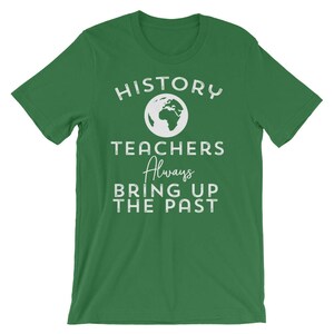 Puede incluir: Camiseta verde con texto blanco que dice "History Teachers Always Bring Up The Past". Un icono de globo blanco est&aacute; por encima del texto.