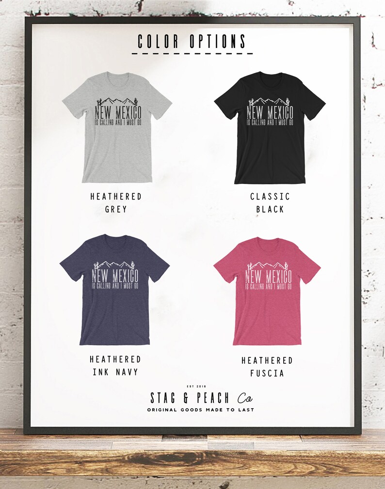 May include: Four t-shirts with different color options: heather grey, classic black, heather ink navy, and heather fuscia. Each t-shirt features a graphic design with the text "New Mexico is calling and I must go". The t-shirts are displayed on a white background with the text "Color Options" and "Stag & Peach Co. Original Goods Made to Last".
