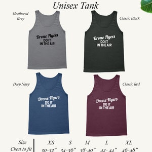 May include: Unisex tank top in five colors: heather grey, classic black, deep navy, classic red, and white. The tank top features the text "Drone Flyers Do It In The Air". Size chart included with chest measurements in inches.