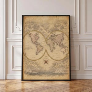 Op de afbeelding: Een ingelijste wereldkaartprint in vintage-stijl met twee cirkelvormige hemisferen tegen een sepia-kleurige achtergrond met wolken en oceaangolven. Een kompasroos bevindt zich tussen de twee globes, met continenten in gedempte bruintinten.