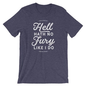 Puede incluir: Una camiseta azul jaspeada con un gr&aacute;fico blanco desgastado que dice "Hell hath no fury like I do" y el texto "Stag & Peach Co. - Genuine Apparel -"