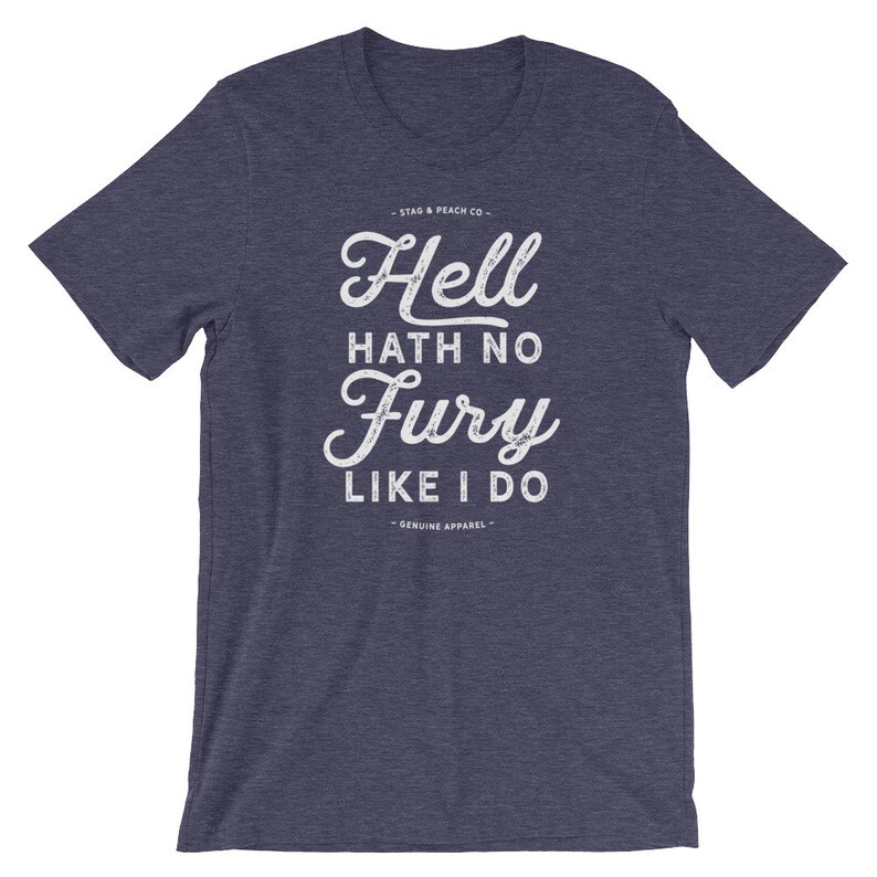Puede incluir: Una camiseta azul jaspeada con un gr&aacute;fico blanco desgastado que dice "Hell hath no fury like I do" y el texto "Stag & Peach Co. - Genuine Apparel -"