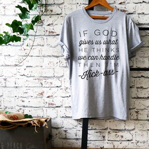May include: Gray t-shirt with black text that reads "If God gives us what He thinks we can handle then I'm -Kick-ass- "