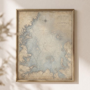 May include: A framed vintage-style map titled Arctic Regions Discovered and Explored During the Years 1818 to 1825. The map features tan landmasses, blue water, a compass rose, and dashed lines indicating exploration routes across the polar sea.